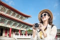 Asian female traveler photographing temples at Asia