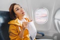 Asian female traveler suffers from an acute attack of nausea during turbulence on a plane. The woman was seasick and airsock Royalty Free Stock Photo