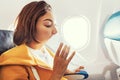 Asian female traveler suffers from an acute attack of nausea during turbulence on a plane. The woman was seasick and airsock Royalty Free Stock Photo