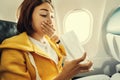 Asian female traveler suffers from an acute attack of nausea during turbulence on a plane. The woman was seasick and airsock Royalty Free Stock Photo