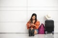 Asian female traveler waiting for flight and using smart phone outside lounge in airport. Travel and people lifestyle concept. Royalty Free Stock Photo