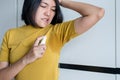 Asian woman using spray with odor sweating,Female smelling or sniffing her armpit,Bad smell Royalty Free Stock Photo