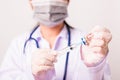 Woman doctor with stethoscope wearing face mask protective in the laboratory holding syringe and medicine vial vaccine Royalty Free Stock Photo