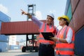 Asian female worker is explaining a check list of container inspections to the supervisor in container depot terminal