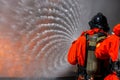 Asian firefighter on duty firefighting, Asian fireman spraying high pressure water, Fireman in fire fighting equipment uniform