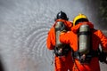 Asian firefighter on duty firefighting, Asian fireman spraying high pressure water, Fireman in fire fighting equipment uniform