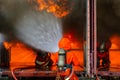 Asian firefighter on duty firefighting, Asian fireman spraying high pressure water, Fireman in fire fighting equipment uniform