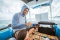 Asian fisherman fixes backlash fishing line on a fishing boat