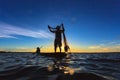 Asian fisherman on wooden boat casting a net for catching Royalty Free Stock Photo