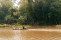 Asian fisherman on wooden longtail boat in nature river