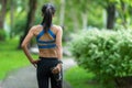 Asian fitness woman runner stretching legs before run outdoor workout in the park. Royalty Free Stock Photo