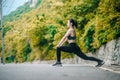 Asian fitness woman runner stretching legs before run outdoor workout in the park. Royalty Free Stock Photo