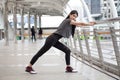 asian fitness young woman stretching leg on a rail bridge workout exercising on street in urban city . runner sport girl warm up
