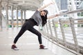 asian fitness young woman stretching leg on a rail bridge workout exercising on street in urban city . runner sport girl warm up