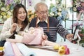 Asian florists family demonstrate flower arrangements via online live streaming.