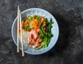 Asian food bowl - rice noodles, shrimp, cabbage bok choy and quickly pickled vegetables carrots, cucumbers, daikon salad on a dark Royalty Free Stock Photo