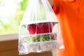 Asian food boxes in plastic bag delivered to customer at home by delivery man