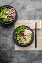 Asian food. Chinese cuisine. Stir fry rice, vegetables and meat with nutty spicy sauce on a bamboo mat. Vertical shot. Top view Royalty Free Stock Photo