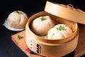 Asian food concept Chinese meat dumpling Baozi in dim sum bamboo steamer on wooden board on black slate stone background with copy Royalty Free Stock Photo