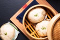 Asian food concept Chinese meat dumpling Baozi in dim sum bamboo steamer on wooden board on black slate stone background with copy Royalty Free Stock Photo