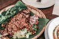 Asian food concept. Deep fried fish, crispy garlic, pepper, decorate with chili, spring onions serve on banana leaf