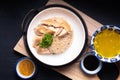 Asian Food concept Hainanese Chicken Rice with sour and sweet soy sauce on wooden board with slate stone background