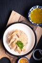 Asian Food concept Hainanese Chicken Rice with sour and sweet soy sauce on wooden board with slate stone background