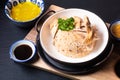 Asian Food concept Hainanese Chicken Rice with sour and sweet soy sauce on wooden board with slate stone background