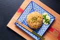 Asian food concept homemade egg fried rice in square ceramic asian style plate on wooden board and black background with copy Royalty Free Stock Photo