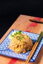 Asian food concept homemade egg fried rice in square ceramic asian style plate on wooden board and black background with copy Royalty Free Stock Photo