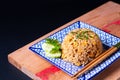 Asian food concept homemade egg fried rice in square ceramic asian style plate on wooden board and black background with copy Royalty Free Stock Photo