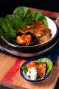 Asian food concept homemade Korean Grilled pork belly BBQ Samgyeopsal-gui with kimchi and shiso and salad on black background with Royalty Free Stock Photo