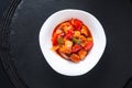 Asian food concept sweet and sour Chicken in white ceramic dish on black slate stone background Royalty Free Stock Photo