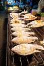 Asian food. Counter with fish in salt on the grill at a night food street market Royalty Free Stock Photo