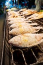 Asian food. Counter with fish in salt on the grill at a night food street market Royalty Free Stock Photo