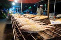 Asian food. Counter with fish in salt on the grill at a night food street market Royalty Free Stock Photo