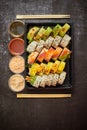 Asian food delivery home, various sushi sets in plastic containers with sauces, rice and chopsticks