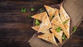 Asian food. Samsa samosas with chicken fillet and cheese on wooden background.