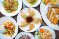 Asian food in Vietnamese restaurant.Fried shrimp rolls and fresh salads served on white plates in overhead view.Delicious seafood Royalty Free Stock Photo