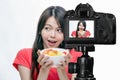 Asian food vlogger with fruit salad behind camera