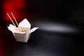 Asian food: wok pasta, spaghetti, with vegatables in white box. black isolated. wooden chopsticks. Concept of production of paper Royalty Free Stock Photo