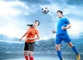 Asian football player jump and duel heading the ball on the air on the football field