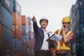 Asian foreman holding clipboard and engineering woman talk radio.