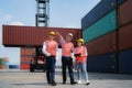 Asian foreman walking and explaining the various operations in the container depot terminal to worker