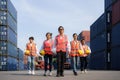 Asian foreman walking with four workers employee team after finishing work on the container depot terminal