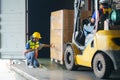 Asian forklift driver loading a shipping cargo container with a full pallet with boxes in logistics port terminal. Asian warehouse Royalty Free Stock Photo