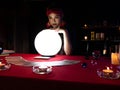 Asian fortune teller woman use crystal lamp light ball and tarot cards for reading customer life and paranormal belief in the dark