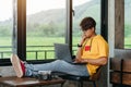 Asian freelance man sitting and thinking content in social network via laptop computer while resting in modern coffee shop, Online