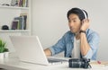 Asian Freelance Videographer Work from Home Testing Multimedia Sound by Laptop in Home Office in Vintage Tone