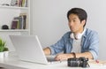 Asian Freelance Videographer Editing Multimedia File by Laptop in Home Office